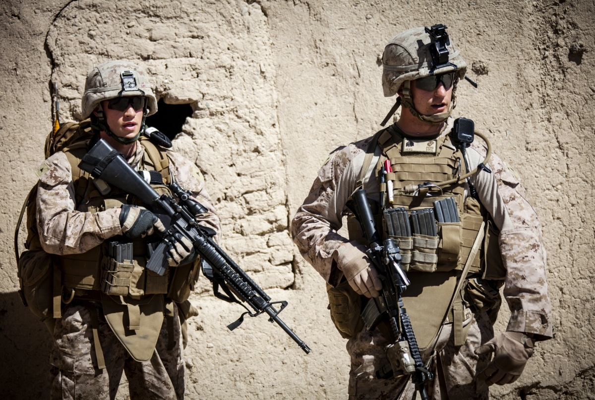 U.S. Marine Corps Lance Cpl. Leo Caldwell, left, and Sgt. Jordan Hicks, right, platoon sergeant Echo company, 2nd Battalion 9th Marines, Regimental Combat Team 7 (RCT) 7, consults his teammates during a combat operation in Helmand province, Afghanistan