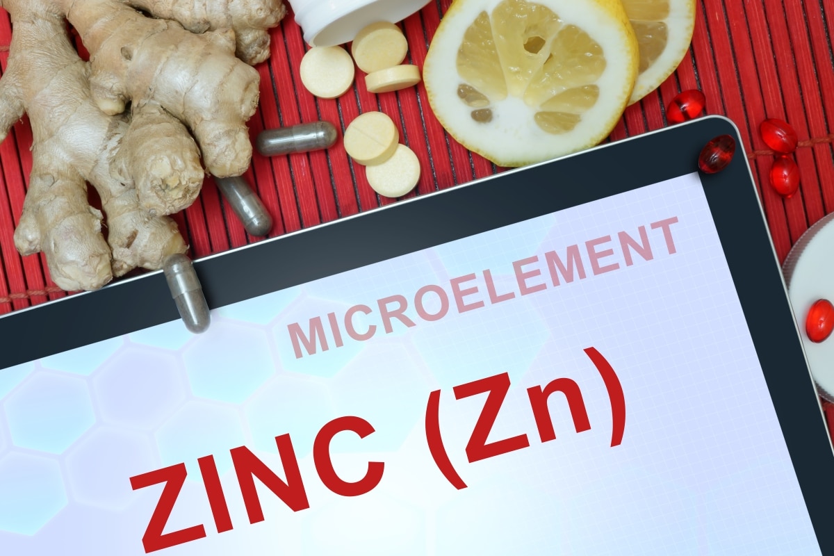 Tablet with words Zinc (Zn), pills, lemon and ginger. Healthy eating.