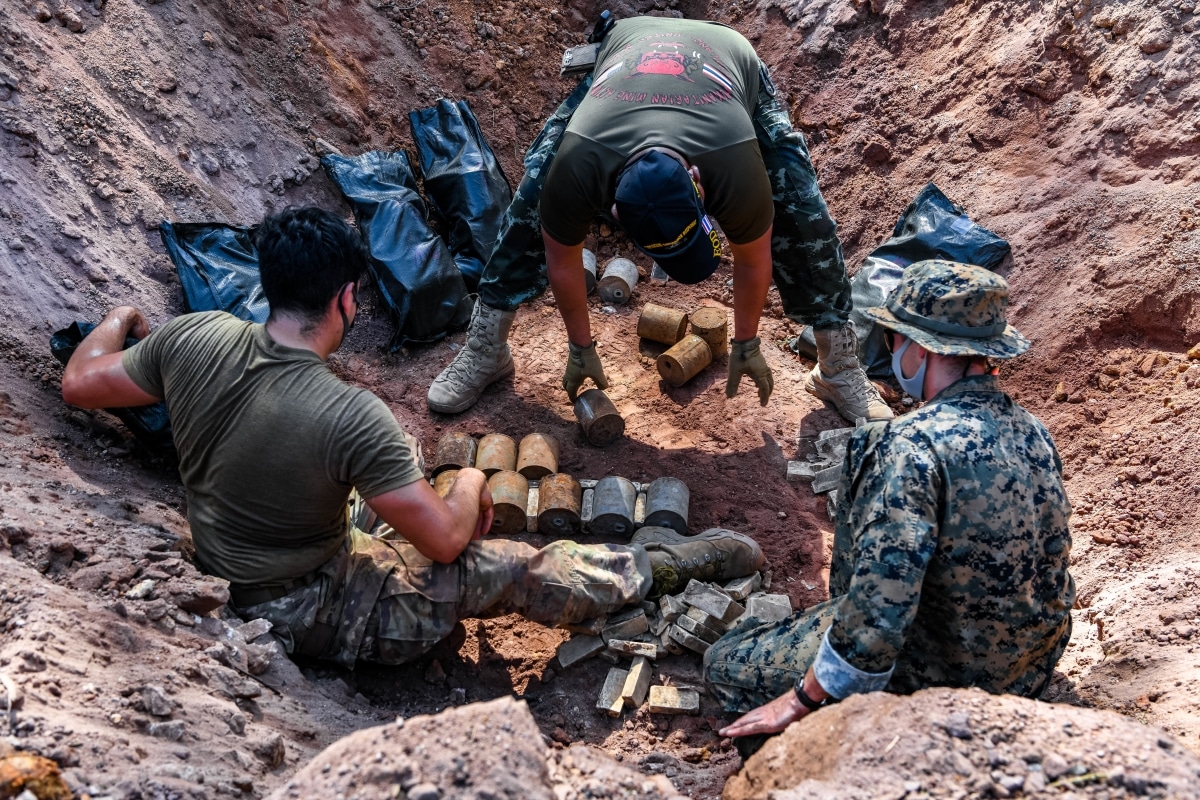 U.S. Air Force Staff Sgt. Justin Campos, left, an explosive ordnance disposal (EOD) technician with 18th Civil Engineer Squadron, Sgt. Maj. 1st Class Thankakorn Ngammeun, center, a deminer with Humanitarian Mine Action Unit 1, and U.S. Marine Corps Sgt. Aaron Pryor, an EOD Technician with EOD Company, 9th Engineer Support Battalion