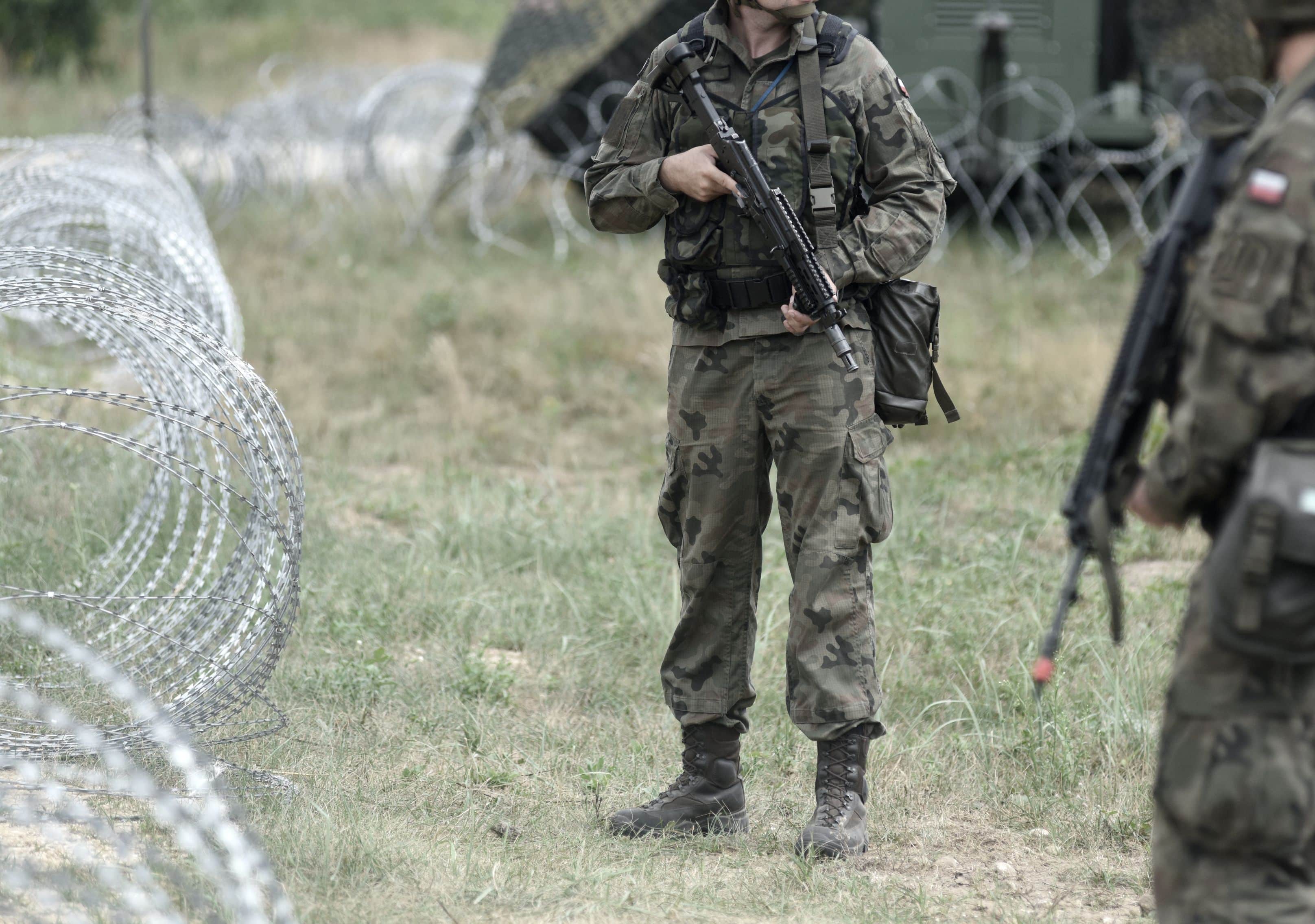 Soldiers of Poland on border. Polish soldiers near a fence on the border