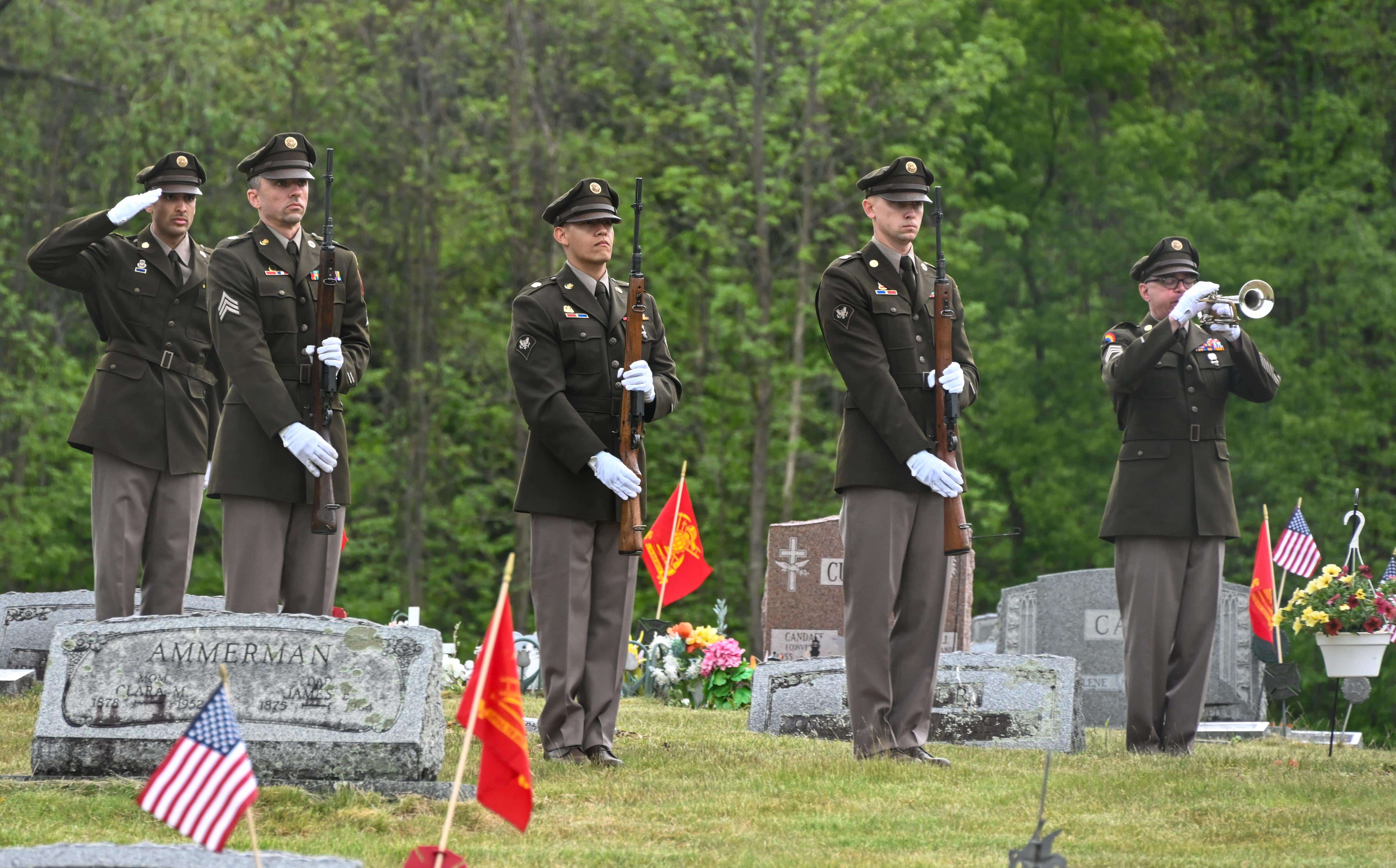 New York Army National Guard Soldiers stand at attention as the bugler sounds taps after firing a rifle salute at the funeral of a 1st Lt. John Thomas, a World War II U.S. Army Air Forces pilot killed in action in 1943